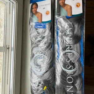 Impression Super Braid hår (Två paket) - Två paket Impression Super Braid i färg 51, ett snyggt mixat grått och svart syntetiskt hår för flätor. Längden är ca 86 cm och håret är lätt att styla till olika looks som jumbo braids, mohawk eller twisted buns. Materialet är mjukt och lätt att arbeta med.
