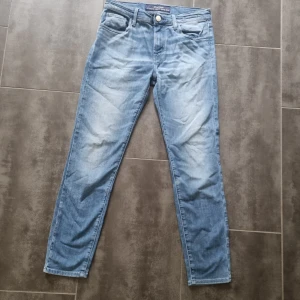 Blå jeans från Jacob Cohën, stl 29 - Snygga ljusblå jeans från Jacob Cohën i klassisk femficksmodell. Jeansen har raka ben, normal passform och är tillverkade i en mjuk bomullsblandning med lite stretch. Perfekta för dig som gillar stilrena och bekväma jeans med italiensk känsla.   Priset är ej hugget I sten och kan budas ner till ett rimligt pris