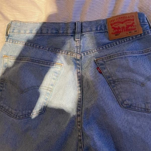 Levi's 501 ljusblå jeans W32 L30 - Klassiska Levi's 501 jeans i ljusblå denim. Rak passform med fem fickor, knappgylf och ikonisk läderpatch bak i midjan. Perfekta för dig som gillar en tidlös och avslappnad look. Snygga till sneakers eller boots.