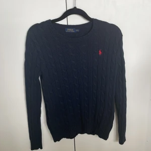Mörkblå kabelstickad tröja Polo Ralph Lauren - Kabelstickad mörkblå tröja från Ralph Lauren. Fint skick och grym kvalitet! Passar bra till grisch och Stockholmsstilen