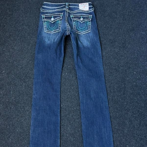 Midrise Straight Jeans - Supersnygga nästan oanvända True Religion Jeans i modellen Billie!💓 Dem har turkosa detaljer och är verkligen såå coola! Tyvärr för små för mig😇 Inköpt för runt 1300kr💓Ca 37cm rakt över midjan och 82cm innerben💓