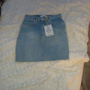 Blå jeanskjol från Pull&Bear - Snygg ljusblå jeanskjol från Pull&Bear med  dragkedja framtill
