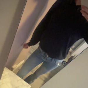 Marinblå hoodie från Gina Tricot - En marinblå hoodie från Gina Tricot med klassisk huva och magficka. Tröjan har långa ärmar och är tillverkad i mjuk bomullsmix, perfekt för en chill och avslappnad stil. Passformen är normal och hoodien är enkel att matcha med jeans eller leggings.