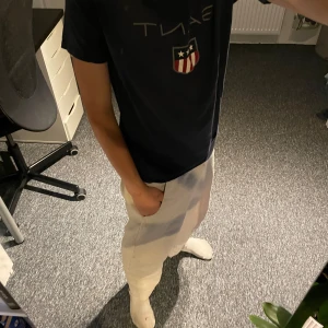 Marinblå GANT t-shirt med tryck - Snygg marinblå t-shirt från GANT med klassiskt tryck och sköld på bröstet. T-shirten har rund hals, korta ärmar och är gjord i mjuk bomull. Perfekt för dig som gillar stilren och sportig look. Storlek står 170 men den passar bra som xs och framför allt S