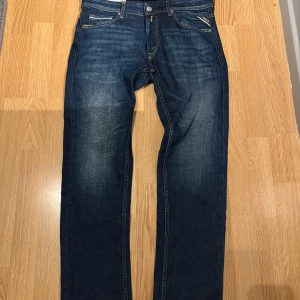 Replay Grover jeans straight fit blå - Säljer ett par mörkblå Replay Grover jeans i straight fit. Klassisk femficksmodell med snygga slitningar och detaljer i kontrastsömmar. Tillverkade i ekologisk bomull för en skön känsla och hållbar stil. Använda cirka 3 gånger
