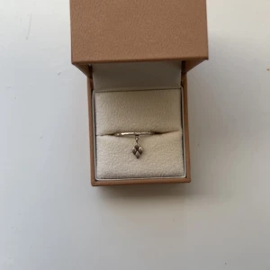 Silverring med hängande symbol - Jättesöt stilren silverring med ett liten hängande symbol som detalj. Säljer då den jag bytt från silver till guld 