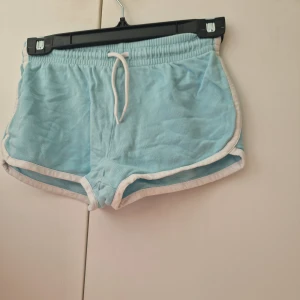 Ljusblå mjukis shorts med vit kant - Ljusblå mjukis shorts från Cubus med vit kant och elastisk midja. 