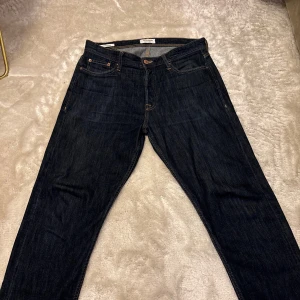 Jack & Jones Loose Chris jeans mörkblå - Mörkblå jeans från Jack & Jones i modellen Loose Chris. Klassisk femficksdesign, kontrastsömmar och lös passform för en avslappnad vibe. Sparsamt använda och inga skador på jeansen. Storlek 31/32 och skick 9/10. Hör av er vid frågor 