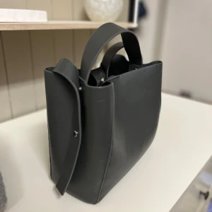 Grå väska gina  - Väska med både handtag och en lång rem, stilren och i bra skick🙌🏼💞🥰