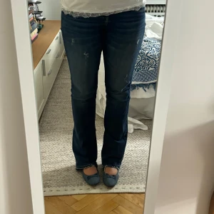 Blå bootcut jeans från LTB - Säljer ett par mörkblå Levis jeans med bootcut passform och klassisk femficksdesign. Jeansen har snygga slitningar framtill och bakfickor med Levis signaturbroderi. Modellen har normal midja och är tillverkad i robust denim med lite stretch för skön känsla.