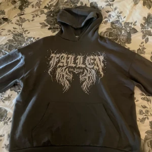 Mörkgrå hoodie med tryck - Mörkgrå hoodie från newyorkers märke FB Sister i storlek XS med stort tryck 'Fallen in Love' i vitt på framsidan. Tröjan har huva, magficka och långa ärmar. Mjuk insida i fleece som gör den extra skön. Säljer då jag inte använder den längre. Bra skick. Endast två fläckar på fickan men syns knappt.