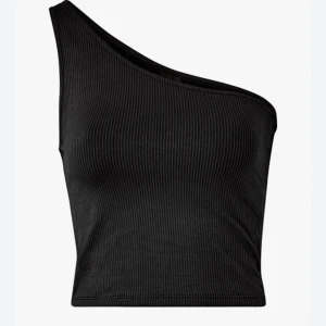 Svart ribbad oneshoulder topp - Snygg svart croppad topp med ribbad struktur och oneshoulder-design. Materialet är mjukt och stretchigt, vilket gör den bekväm att bära. Passformen är tight och toppen är ärmlös med en cool asymmetrisk skärning! Endast använd några få gånger, storlek xs!💞