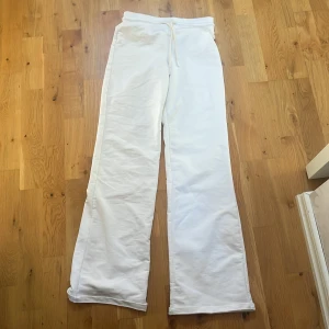 Vita mjukisbyxor från 157, XXS - Säljer ett par vita mjukisbyxor från 157 i storlek XXS. De har en bred, elastisk midja med snörning och raka, loose ben. Materialet är mjukt bomullstyg som känns skönt mot huden. Perfekta för chill dagar eller när du vill vara extra comfy.