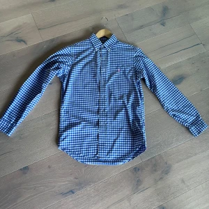 Blårutig skjorta från Ralph Lauren - Hej! Säkjer nu denna snygg blårutig skjorta från Ralph Lauren med klassisk krage och knappar hela vägen. Skjortan har lång ärm och är i en normal passform. Materialet är mjuk bomull som känns skönt mot huden. Perfekt för dig som gillar stilrena och tidlösa mönster. Andvänd väldigt lite, men väldigt fin. Tveka inte en sekund på att höra av dig! MVH Leo. Ps pris ej hugget i sten