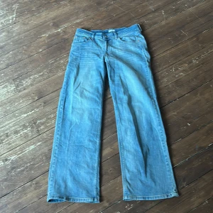 Blå loose jeans från Nelly, EU 38 - Säljer ett par ljusblå loose  jeans från Nelly i storlek EU 38. Modellen har låg midja, raka och breda ben samt klassiska fem fickor. Jeansen är tillverkade i jeansmaterial och har en chill vibe med skön passform.