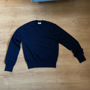 Mörkblå tröja från Sandö - Mörkblå stickad tröja från Sandö. Köpt på Åhléns.  Tröjan är i bra skick och jag har använt den fåtal gånger. Hör av er vid vid minsta funderingar!