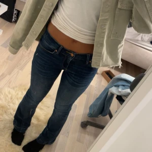 Mörkblå bootcut jeans från LTB - Snygga mörkblå jeans från LTB med klassisk bootcut passform. Jeansen har normal midja, fem fickor och coola slitningar framtill. Materialet är stretchigt denim som sitter skönt och formar sig efter kroppen. Perfekta till sneakers eller boots. Storlek 26x30 modell fallon