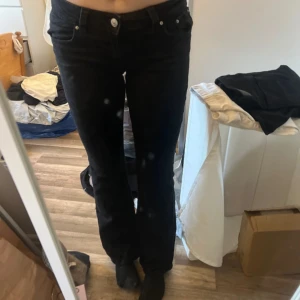 Svarta bootcut jeans - Säljer ett par svarta jeans med bootcut-modell. Byxorna har klassisk femficksdesign, normal midja och stängs med knapp och dragkedja. Perfekta för dig som gillar en tidlös och snygg look.