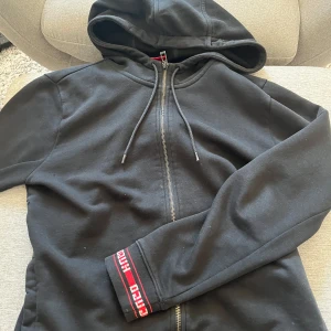 Svart hoodie från Hugo med dragkedja - Svart hoodie från Hugo med hel dragkedja och huva. 