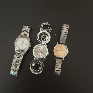 Tre silvriga armbandsur i metall - Säljer tre stilrena armbandsur i silverfärgad metall. Regent har klassisk design med vit urtavla, Xone har en unik länk med cirklar och kristalldetaljer samt silver urtavla, Seiko har en enkel och elegant beige urtavla med flexlänk. Perfekt för dig som gillar snygga accessoarer.