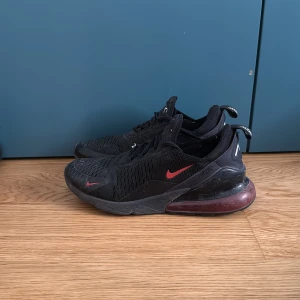 Nike Air Max 270 svart/röd strl 42 - Nike Air Max 270 sneakers i svart med röda detaljer. Rätt så använda men riktigt sköna och bra kvalité på skorna. Pris kan diskuteras!