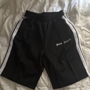 Svarta shorts från Palm Angels med vita ränder - Svarta shorts från Palm Angels, aldrig använt. Säljer pga för stor storlek för mig. Storleken är S.