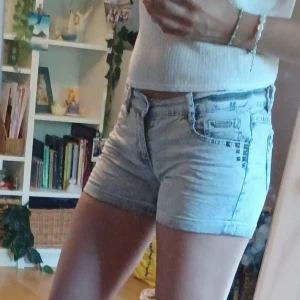 Grå jeansshorts med nitar  - Snygga grå jeansshorts från Lab Industries med coola silverfärgade nitar vid fickorna och broderade detaljer på bakfickorna🦝🤍🐚 Jag är storlek s/m och kan få på mig dem men de sitter väldigt tajt. Storlek 164. Det är bara att skriva om man har frågor!😊💖