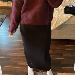 Svart långkjol i mjukt tyg - Säljer en svart långkjol. Kjolen har en rak och tight passform som sitter snyggt längs kroppen. Materialet känns mjukt och följsamt. ❤️