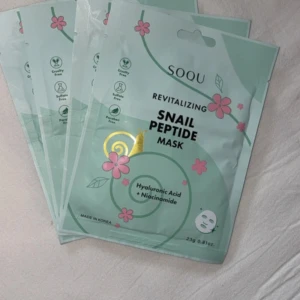 SOQU Snail Peptide Mask - Revitalizing ansiktsmask från SOQU med snigelpeptider, hyaluronsyra och niacinamid. Masken kommer i mintgrön förpackning med rosa blommor och är tillverkad i Korea. Cruelty free, sulfatfri och parabenfri. Perfekt för dig som vill boosta huden med fukt och glow.                             Styckvis 40kr Alla 4 för 160