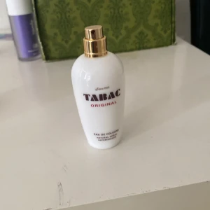 Tabac Original Eau de Cologne 50ml - Tabac Original Eau de Cologne i en vit, stilren flaska med guldfärgad spraytopp. Flaskan rymmer 50 ml och har klassisk logga framtill. Parfymen är tillverkad av Maurer & Wirtz i Tyskland och har en tidlös, maskulin doft.
