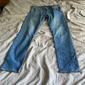 Blå raka jeans från Weekday - Säljer ett par klassiska blå jeans från Weekday med raka ben och fem fickor. Jeansen har normal passform och är tillverkade i slitstarkt denim med ljus tvätt. Perfekt för dig som gillar enkel och tidlös stil. Storlek W31 L34                              