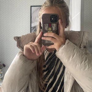 Beige pufferjacka från 157 - Säljer en beige pufferjacka från 157 med hög krage och fluffig känsla. Jackan har långärmade ärmar och dragkedja framtill. Utsidan är i syntetmaterial och insidan har mjuk fleece. Perfekt för kalla dagar och riktigt snygg till jeans eller mjukis.