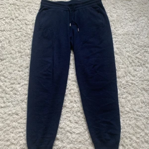 Mörkblå cashmerebyxor John Henric - Mysiga mörkblå mjukisbyxor från John Henric i lyxig cashmere. Byxorna har resår i midjan med snörning och ribbade muddar vid bensluten. Perfekta för chill eller när du vill ha det extra bekvämt. Nypriset ligger runt 2499kr för ett par liknande. Fint skick. 