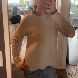 Beige stickad tröja med rund hals - Mysig beige stickad tröja med rund halsringning och långa ärmar. Tröjan har ribbade muddar vid ärmslut och nederkant, perfekt för lager-på-lager och chill vardagsstil. Passar dig som gillar enkel och clean look. Är lite nopprig men annars väldigt fin❤️