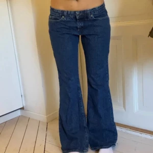 Lågmidjade bootcut jeans från only  - Snygga blå jeans från ONLY med klassisk bootcut-passform och låg midja. Jeansen har fem fickor, tydliga sömmar och en mörkblå tvätt. Perfekta för dig som gillar retrovibbar och vill ha ett par jeans med lite utsvängda ben. Storlek w30 L32 