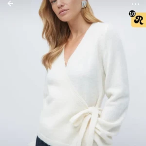 Vit omlottkofta med knyt - Säljer en supermjuk vit omlottkofta med knyt i sidan och v-ringad hals. Koftan har långa ärmar och är perfekt för lager-på-lager-stil. Enkel och stilren design som passar till många outfits. Skicka om ni vill ha mer bilder.