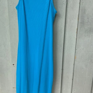 Blå ribbad långklänning Reserved - Säljer en snygg blå långklänning från Reserved i storlek S. Klänningen är ärmlös och har en ribbad struktur som ger en cool och modern känsla. Perfekt för dig som gillar enkel men stilren design och vill sticka ut med färg.