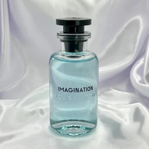 Louis Vuitton Imagination parfym - Lyxig parfym från Louis Vuitton i modellen Imagination. Flaskan är cylindrisk i klart glas med ljusblå vätska och svart rund kork. Kommer i elegant vit förpackning med silverdetaljer och tryckt logga. Perfekt för dig som gillar exklusiva dofter och snygg design.