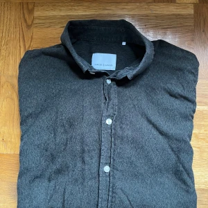 Mörkgrön skjorta från Samsøe Samsøe Stolek S - Snygg mörkgrå skjorta från Samsøe Samsøe i storlek S. Skjortan har klassisk krage, långa ärmar och knappar framtill. Materialet är mjukt och känns som bomull, perfekt för en chill och stilren look.