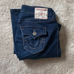 True Religion Joey Low Rise Flare Jeans - Säljer ett par mörkblå True Religion Joey jeans med låg midja och flare. As snygga fickor använda nån gång. Köpta för 1300!!🩷