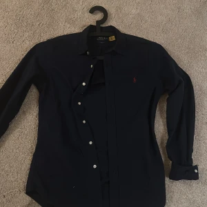 Ralph lauren skjorta marinblå - Säljer en ren skjorta i marin blå från polo Ralph lauren, inte så mycket använde kanske runt 5 gånger.