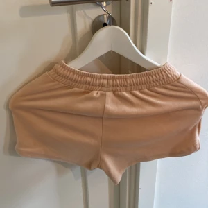 Beiga shorts med snörning från Lindex - Snygga beiga shorts från Lindex med elastisk midja och snörning framtill. De är tillverkade i mjukt material och har en avslappnad passform, perfekta för varma dagar. Enkla att matcha med t-shirt eller hoodie.