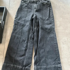 Grå wide jeans från Zara - Säljer ett par gråa jeans från Zara i storlek 32. Byxorna har breda ben, hög midja och markerade sömmar framtill. Tillverkade i klassiskt jeanstyg och har fickor både fram och bak. Perfekta för en avslappnad och trendig look.