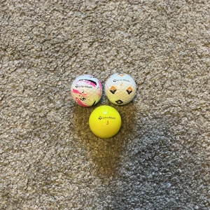 Begagnade golfbollar 3 pack  - Bilderna visar tre olika golfbollar från TaylorMade: en SpeedSoft med färgstarkt mönster, en TP5x med geometriska former och en gul Distance+. Perfekt för dig som vill sticka ut på golfbanan och testa olika bollar för att hitta din favorit.