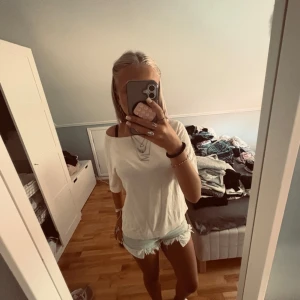 Vit/beige offshoulder t-shirt från H&M - Vit/beige t-shirt från H&M i offshoulder-modell med korta ärmar. Bästälde men glömde lämna tillbaka och är för stor, man kan ha den på ena axeln, nyskick. Skriv för frågor eller fler bilden, tryck gärna köp nu😌