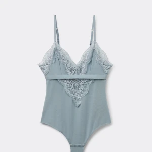 body från intimissimi - Supersnygg ljusblå body med tunna axelband och v-ringad spetsdetalj framtill. Endast testad! Bodyn har en mjuk och stretchig känsla, spetsen ger en extra touch. Fin att styla med både nåt mer fancy som kostymbyxor eller kjol men funkar verkligen till en mer vardaglig look med jeans. Säljer då den inte passar. Verkar vara slutsåld på hemsidan