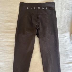 Bruna Prime Scrunch leggings från Relode - Mörkbruna seamless leggings från Relode med hög midja och diskret scrunch-detalj bak. Stretchigt och mjukt material som sitter tight och bekvämt. Perfekta för träning eller chill. Stilren design med logga i midjan.
