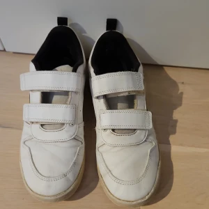 Vita Adidas sneakers  - Snygga vita Adidas sneakers med svarta detaljer och klassiska ränder på sidan. Pris kan diskuteras vid köp 