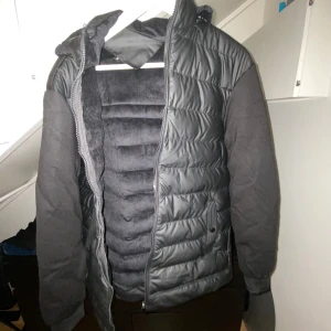 Svart pufferjacka med huva - Snygg svart pufferjacka med quiltad framsida och rygg, samt tjocka svarta ärmar. Aldrig använd 