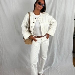 Vita raka/straight lågmidjade jeans  - Snygga vita jeansbyxor med rak passform och klassisk femficksdesign. Byxorna har låg midja. Perfekta att matcha med en enkel topp eller jacka för en clean look. Storlek 27/32. De har en liten fläck på baksidan som knappt syns. 